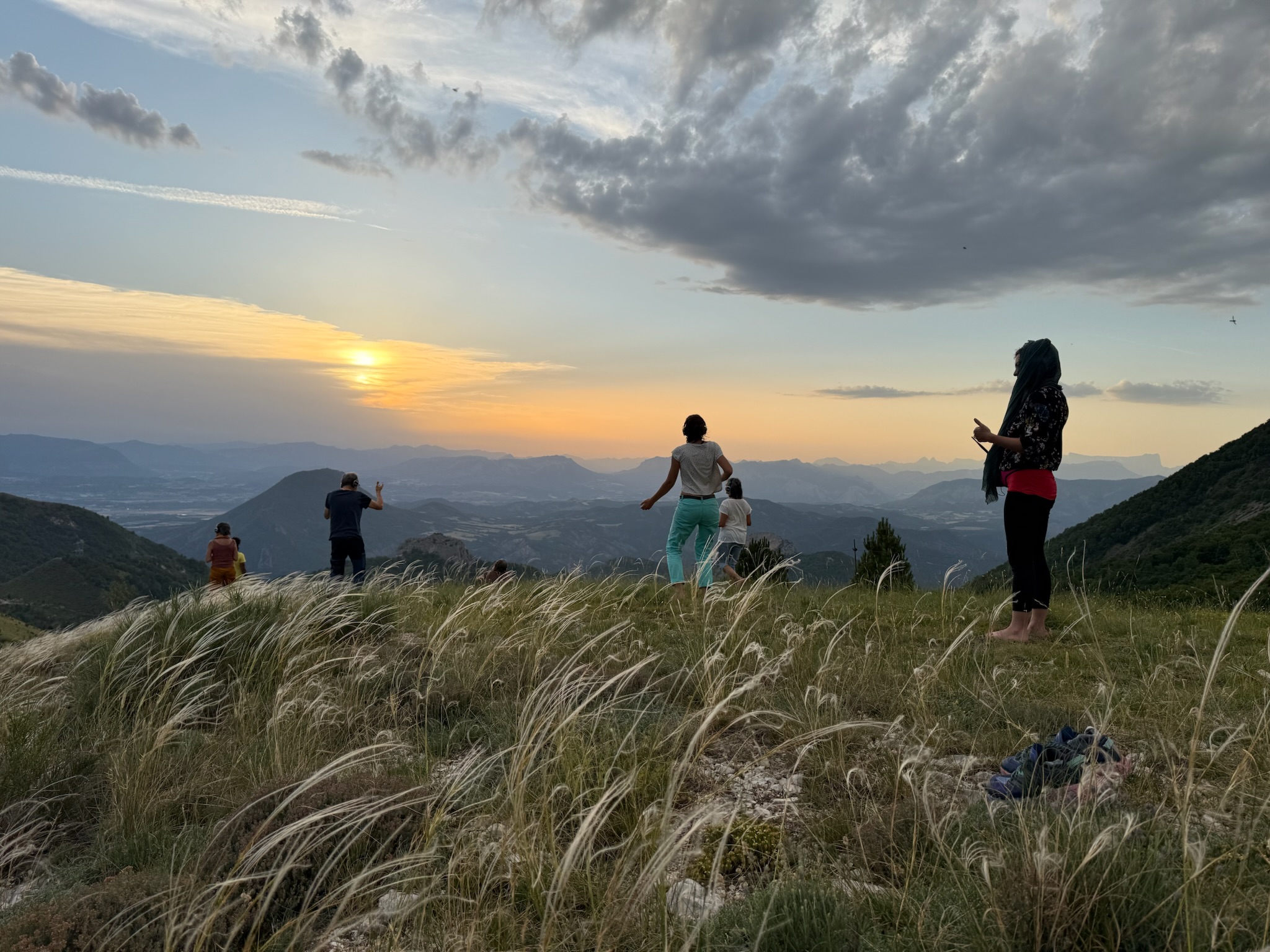 Groupe dansant face au coucher de soleil en crête
